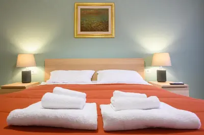 a bedroom with a large orange bed with white pillows at Prosper House in Rome