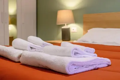 a pile of towels sitting on top of a bed at Prosper House in Rome