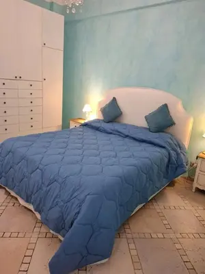 a bedroom with a large blue bed with blue sheets at Le chat bleu in Rome