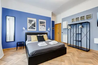a bedroom with blue walls and a large bed at Ferravilla Apt, 2 min to subway! in Rome