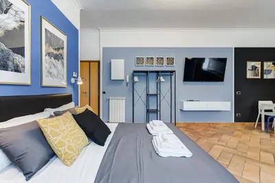 a bedroom with a large bed with a tv on the wall at Ferravilla Apt, 2 min to subway! in Rome