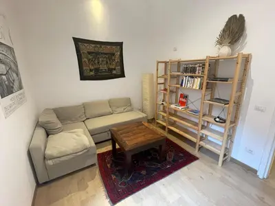 a living room with a couch and a book shelf at Theo's House in Rome Ostiense in Rome