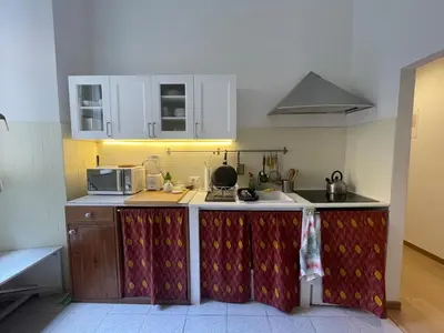 a kitchen with white cabinets and a counter top at Theo's House in Rome Ostiense in Rome