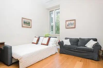 a living room with a couch and a bed at DAMA APARTMENT 2 camere da letto 2 bagni con doccia in Rome