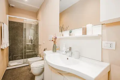 a white bathroom with a toilet and a sink at DAMA APARTMENT 2 camere da letto 2 bagni con doccia in Rome