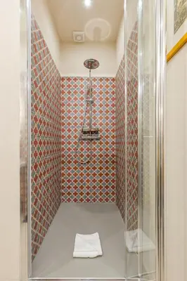 a bathroom with a shower with a glass door at Rome As You Feel - Charming Space at Torre Argentina in Rome