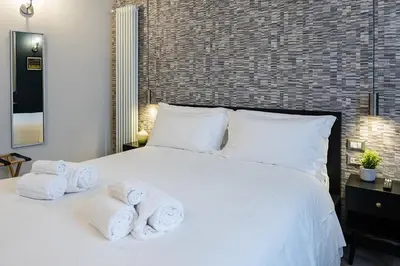 a bedroom with a white bed with towels on it at SONUS Colosseum in Rome