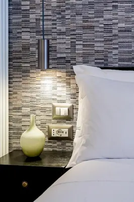 a bed with a white pillow and a vase on a table at SONUS Colosseum in Rome
