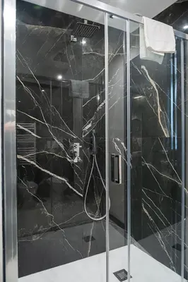 a bathroom with a shower with black marble at SONUS Colosseum in Rome