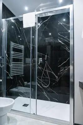 a bathroom with a glass shower with a sink at SONUS Colosseum in Rome