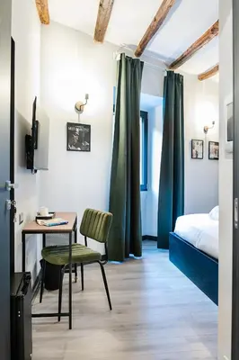 an empty hallway with a green door and a chandelier at SONUS Colosseum in Rome