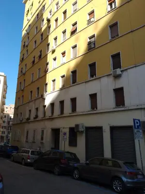 a large building with cars parked in front of it at GuestHost - San Giovanni Comfy Apartment in Rome