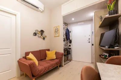 a living room with a brown couch and yellow pillows at GuestHost - San Giovanni Comfy Apartment in Rome