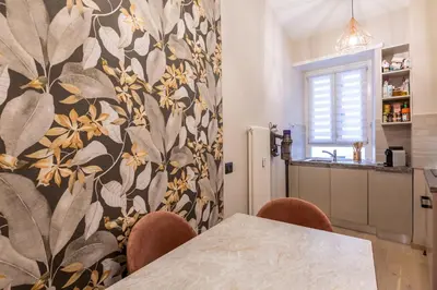 a dining room with a table and chairs and a kitchen at GuestHost - San Giovanni Comfy Apartment in Rome