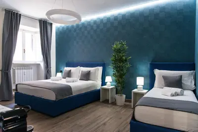 a bedroom with two beds and a blue wall at St Peter Manor 2 - St Peter Manor 3 in Rome
