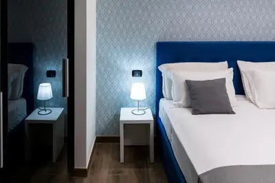 a bedroom with a blue headboard and two tables with lamps at St Peter Manor 2 - St Peter Manor 3 in Rome