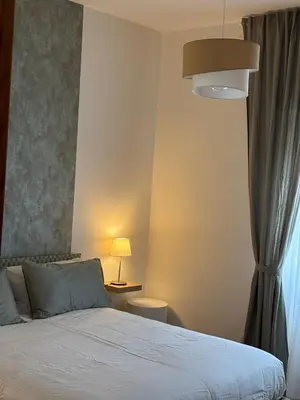 a bedroom with a bed and a lamp and a window at Gina's House Trastevere Station in Rome