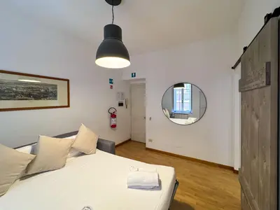 a bedroom with a bed and a round mirror at JHHIT - San Pietro First Suite in Rome