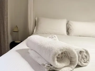 a pile of towels sitting on top of a bed at JHHIT - San Pietro First Suite in Rome