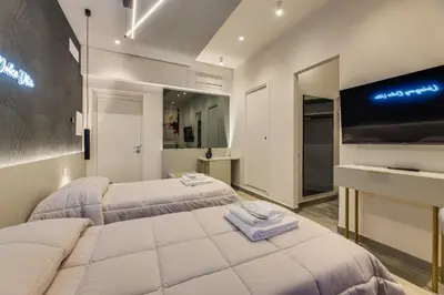 two beds in a room with a flat screen tv at Belli Vatican Suites by Flatinrome in Rome