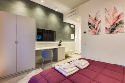 a bedroom with a purple bed and a desk at Belli Vatican Suites by Flatinrome in Rome
