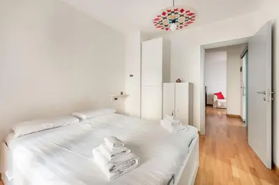 a white bedroom with a large bed with white sheets at Private Condo Terrace & Parking in Rome