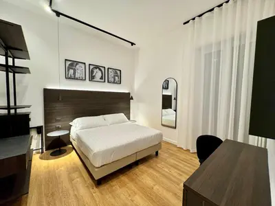 a bedroom with a bed and a table and a desk at Museum Hospitality - Vatican Apartments in Rome