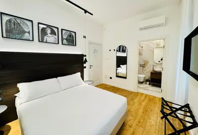 a bedroom with a large white bed and a bathroom at Museum Hospitality - Vatican Apartments in Rome