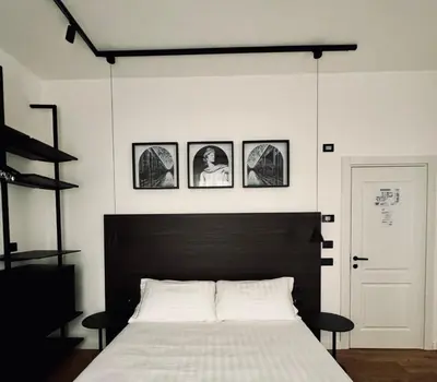 a bedroom with a bed with four pictures on the wall at Museum Hospitality - Vatican Apartments in Rome