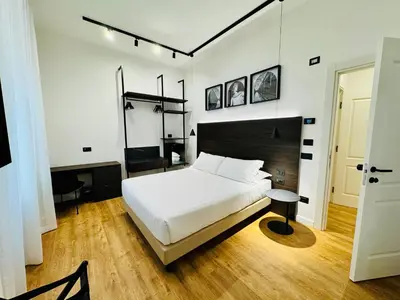 a bedroom with a large white bed and a table at Museum Hospitality - Vatican Apartments in Rome