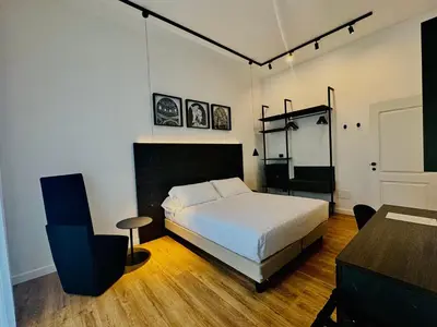 a bedroom with a bed and a table and a chair at Museum Hospitality - Vatican Apartments in Rome