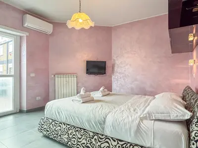 a bedroom with a large bed with a pink wall at Portuense Paradise in Rome