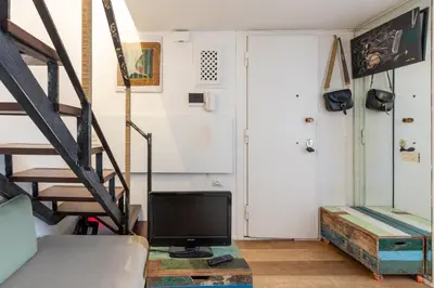 a living room with a tv and a staircase at iFlat Monti Studio Apartment in Rome