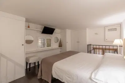 a bedroom with a large white bed and a balcony at iFlat Monti Studio Apartment in Rome