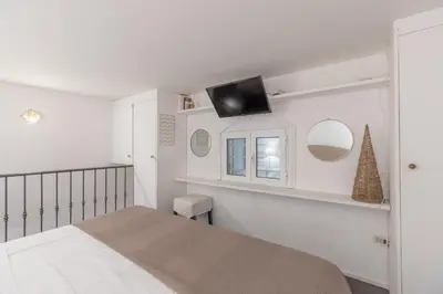 a bedroom with a bed and a tv on a wall at iFlat Monti Studio Apartment in Rome