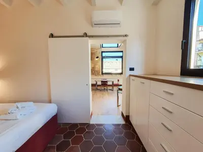 a room with a bed and a kitchen with a window at CS Stylish Loft with Terrace Spanish Steps in Rome