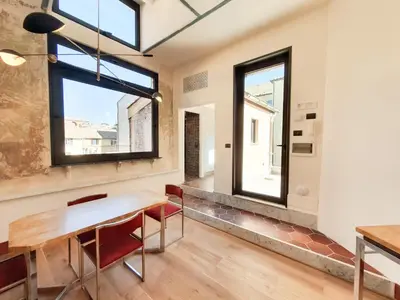 a dining room with a table and chairs and windows at CS Stylish Loft with Terrace Spanish Steps in Rome