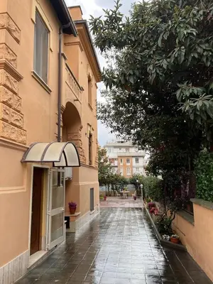 an empty alley between two buildings with an awning at Villa dei fiori in Rome