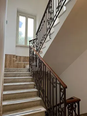 a staircase with wooden railings and a window at Villa dei fiori in Rome