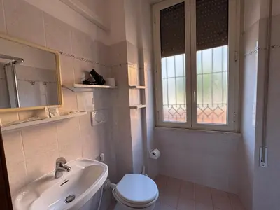 a bathroom with a sink and a toilet and a window at Villa dei fiori in Rome