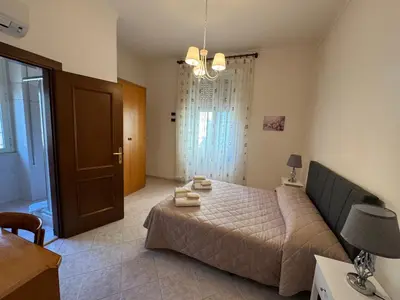 a bedroom with a bed and a table and a door at Villa dei fiori in Rome