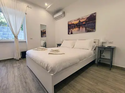 a bedroom with a large white bed and a window at San Pietro Experience in Rome