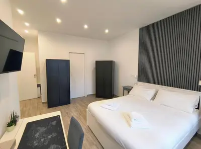a bedroom with a large white bed and a tv at San Pietro Experience in Rome
