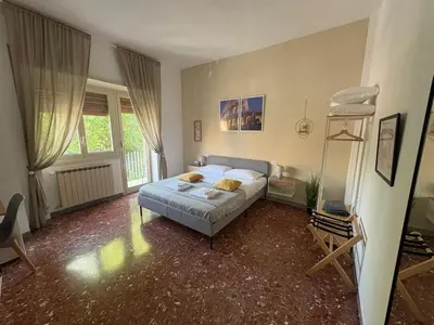 a bedroom with a bed and a chair in it at Quattro Venti city suites in Rome