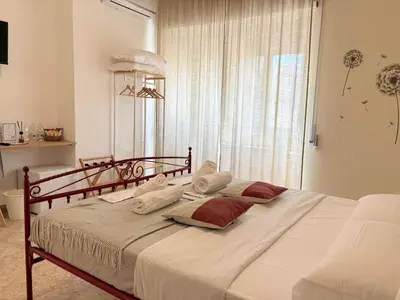 a bedroom with a bed with white sheets and red pillows at Quattro Venti city suites in Rome