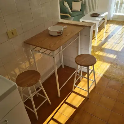 a kitchen island with two stools and a bowl on it at L' attichetto in Rome