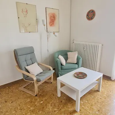 a living room with two chairs and a coffee table at L' attichetto in Rome