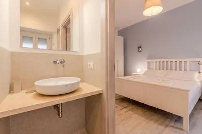 a bathroom with a sink on a counter and a bed at Maria Magdalena Apartment Saint Peter's in Rome