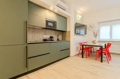 a kitchen with red chairs and a table in a room at Maria Magdalena Apartment Saint Peter's in Rome