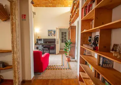 a living room with a red chair and bookshelves at Vicino alla Basilica di Santa Maria Maggiore in Rome
